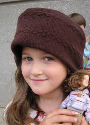 girl with doll in brown hat